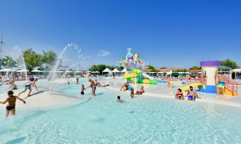 Außenpool mit Wasserspielen und bunten Rutschen.