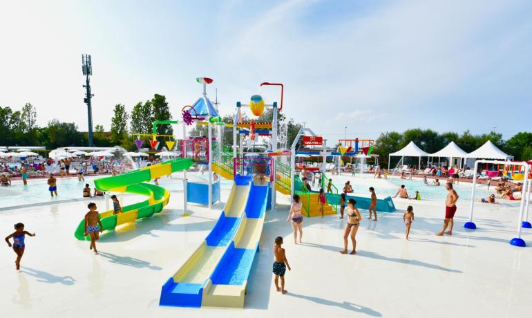 Wasserpark mit Rutschen und Pools, Kinder und Erwachsene genießen die Sonne.