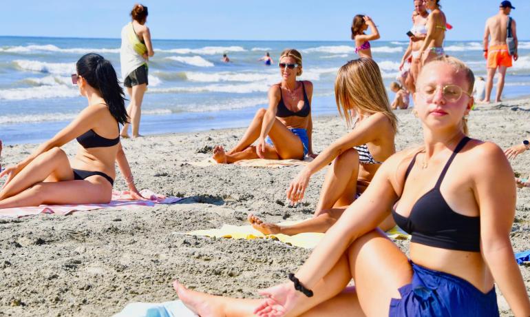 Menschen entspannen sich am Strand an einem sonnigen Tag.