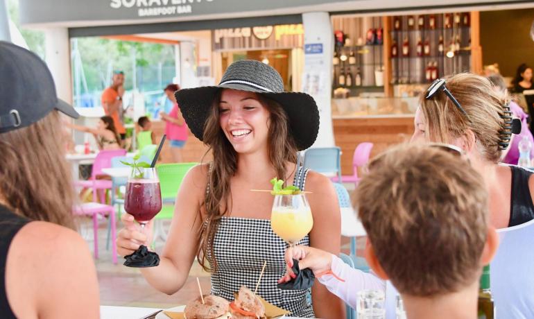 Freundesgruppe stößt im Soravento Bar mit Cocktails und Essen an.