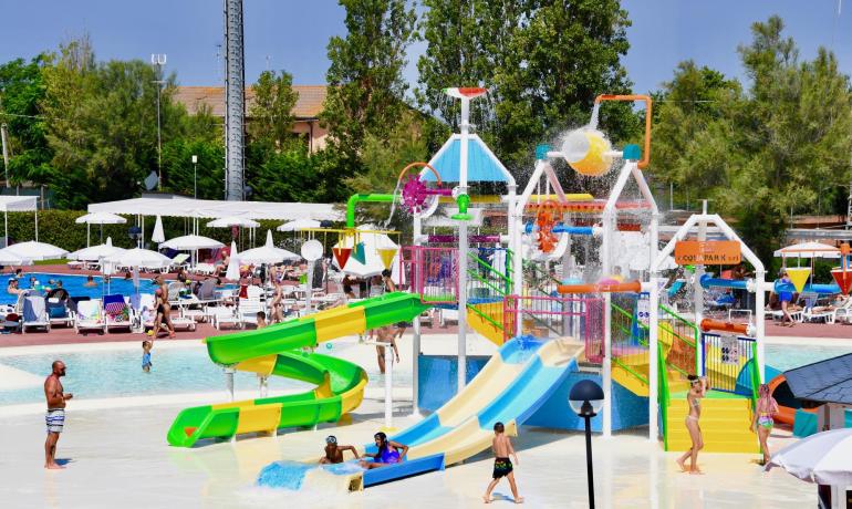 Wasserpark mit bunten Rutschen und spielenden Kindern.