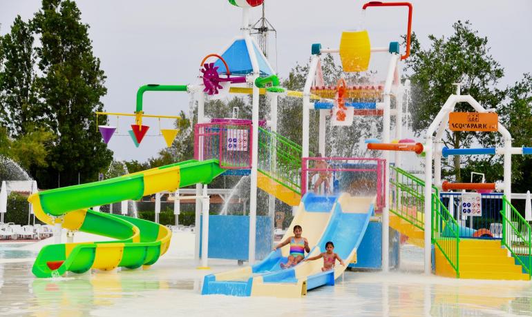 Parco acquatico colorato con scivoli e giochi d'acqua per bambini.