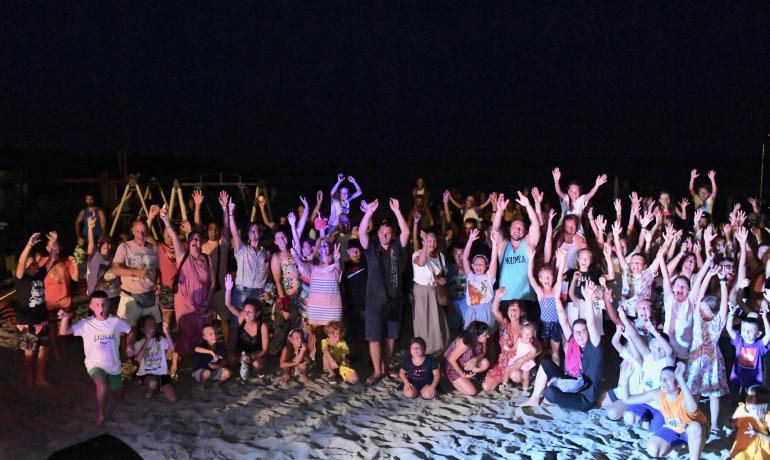 Gruppe von Menschen, die nachts am Strand feiern.