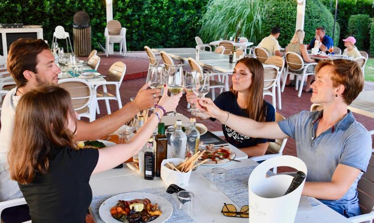 Quattro amici brindano insieme in un ristorante all'aperto.