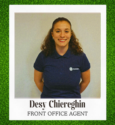 Desy lächelt selbstbewusst in blauer Frontoffice-Uniform.