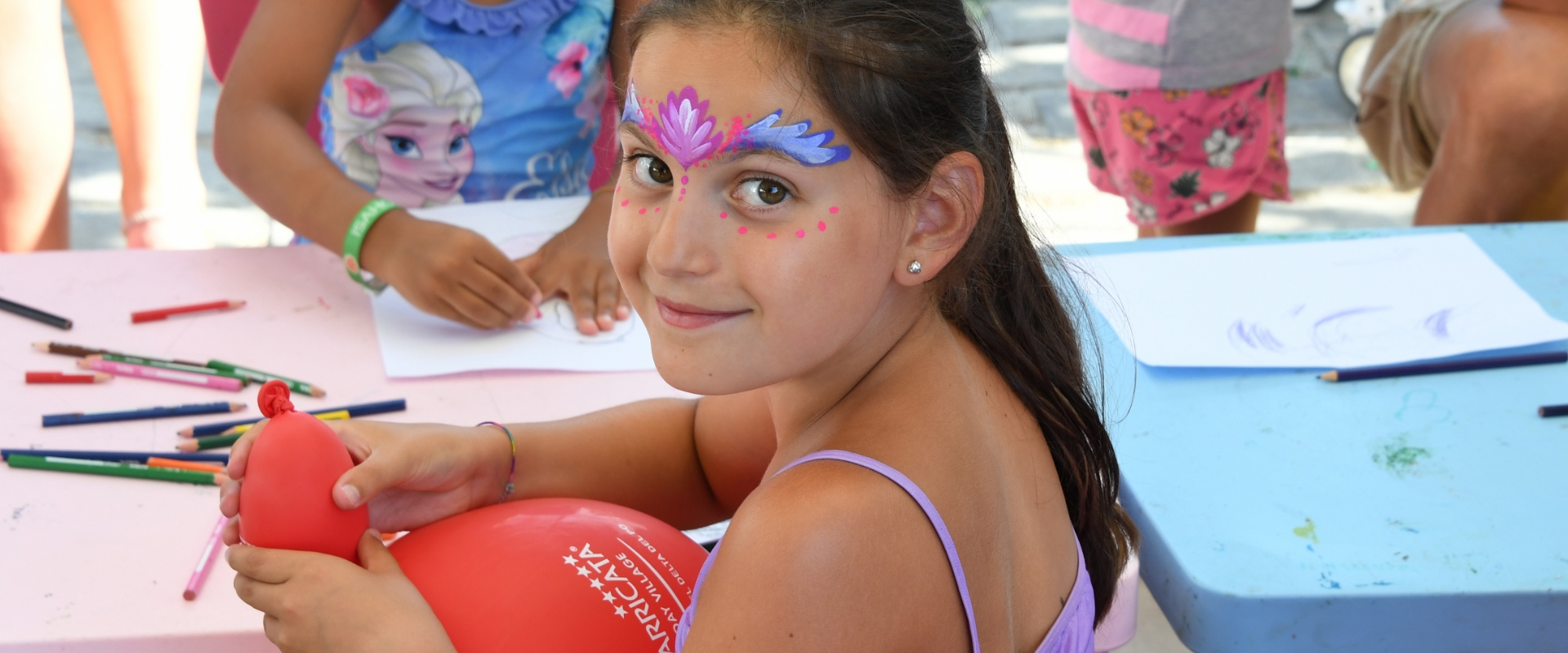 Famiglia in vacanza gioca a palla davanti a una casetta in campeggio.