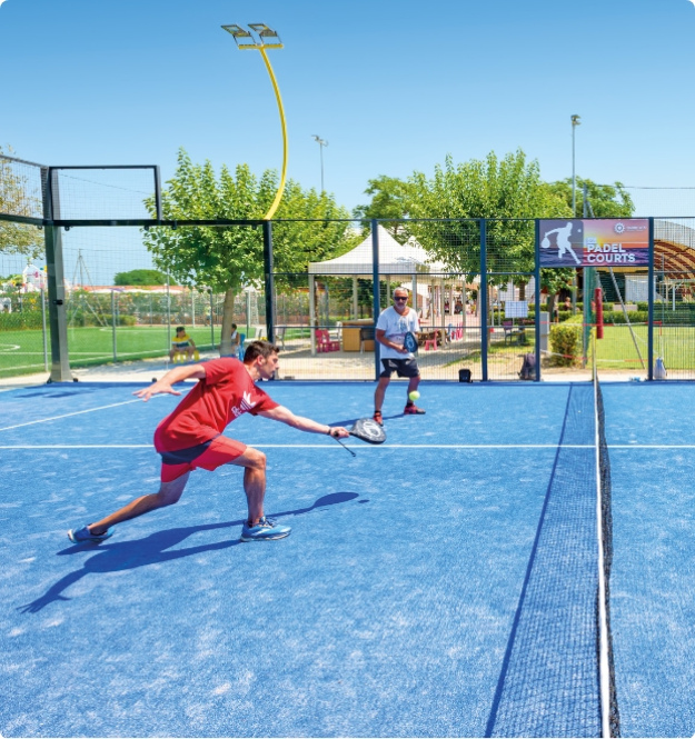 Due persone giocano a padel su un campo blu all'aperto.