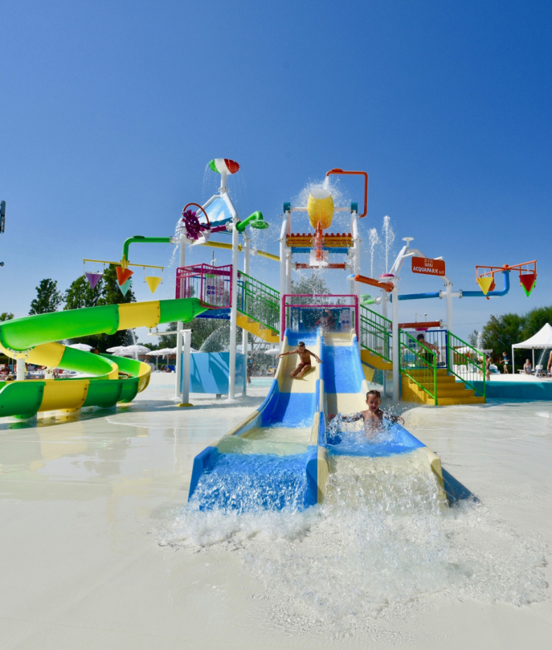 Parco acquatico con scivoli colorati e giochi d'acqua per bambini.